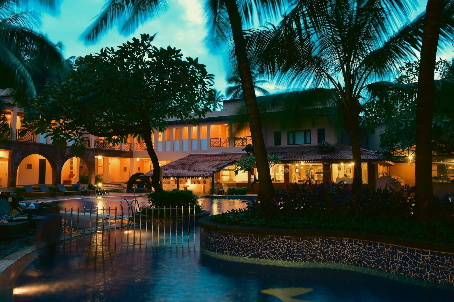 Lush outdoor garden courtyard at Tropicana Gardens Resort with evening ambient lighting